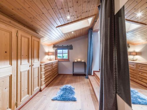 a bathroom with wooden cabinets and blue rugs at Wagstaett Loft by Apartment Managers in Jochberg
