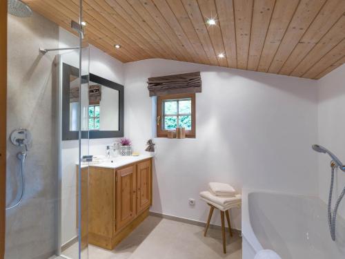 a bathroom with a tub and a sink and a shower at Wagstaett Loft by Apartment Managers in Jochberg