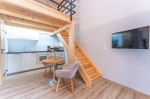a kitchen and dining room with a wooden staircase and a table at Natura Ferienpark - Bungalows am Grimnitzsee Schorfheide in Althüttendorf