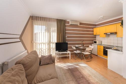 ハイドゥソボスローにあるArt Erika Apartmentのリビングルーム(ソファ付)、キッチン(黄色のキャビネット付)