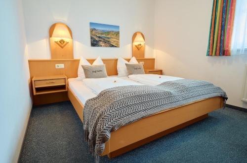 a bedroom with a large bed in a room at Alpendorf Hotel Stern in Sankt Johann im Pongau