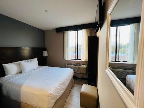 ein Hotelzimmer mit einem Bett und zwei Fenstern in der Unterkunft Rockaway Hotel in Brooklyn