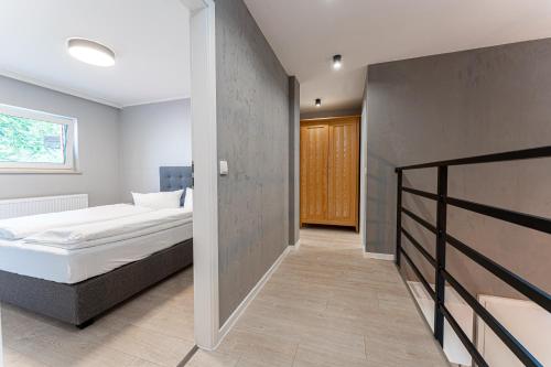 a bedroom with a bed and a hallway at Natura Ferienpark - Bungalows am Grimnitzsee Schorfheide in Althüttendorf