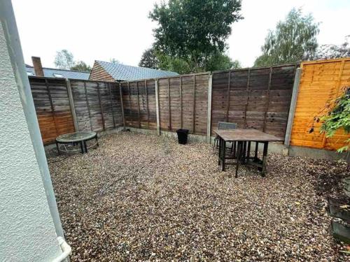 a backyard with a table and a bench and a fence at Silver Stag Properties,Comfy House in Coalville in Hugglescote
