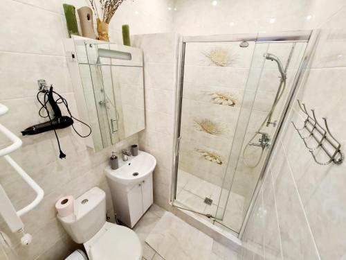 a white bathroom with a shower and a toilet at Center of Odessa. Comfortable 2 rooms apartment in Odesa