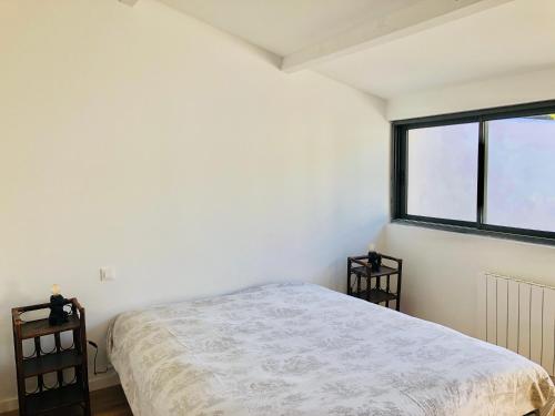 une chambre avec un lit et une fenêtre dans l'établissement Maison familiale, à 100 mètres plage., à La Couarde-sur-Mer