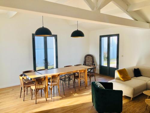 un salon avec une table, des chaises et un canapé dans l'établissement Maison familiale, à 100 mètres plage., à La Couarde-sur-Mer