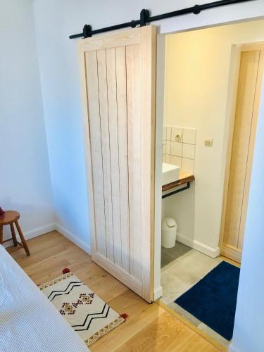 - une chambre avec une porte coulissante et un lavabo dans l'établissement Maison familiale, à 100 mètres plage., à La Couarde-sur-Mer