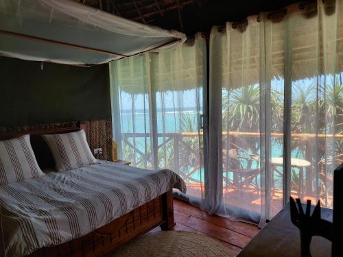 A bed or beds in a room at Mtende Beach Bungalow océan view