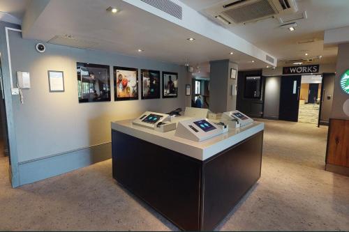 a lobby with a counter in a building at Village Hotel Wirral in Bromborough