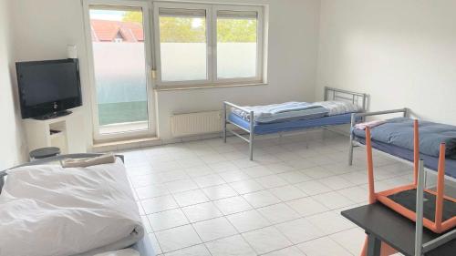 Habitación con 2 camas y TV de pantalla plana. en work & stay apartment mit WLAN & Balkon en Sankt Augustin