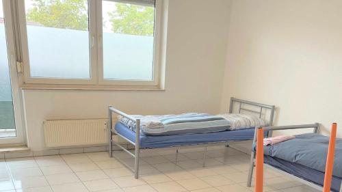 2 camas en una habitación con 2 ventanas en work & stay apartment mit WLAN & Balkon, en Sankt Augustin