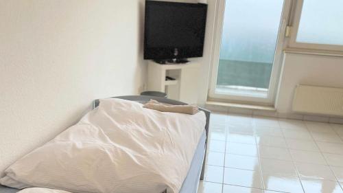 Una cama de hospital en una habitación con TV en work & stay apartment mit WLAN & Balkon en Sankt Augustin