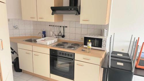 cocina pequeña con fogones y microondas en work & stay apartment mit WLAN & Balkon, en Sankt Augustin