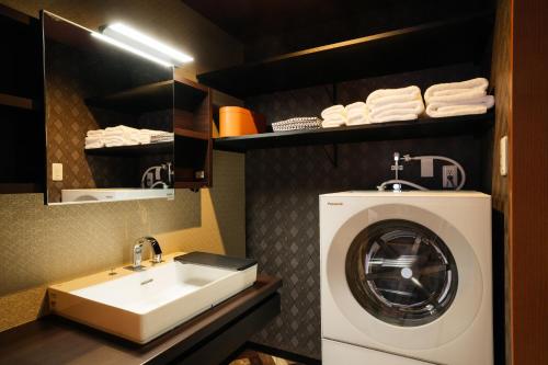 a bathroom with a washing machine and a sink at Weskii Hotel in Kanazawa