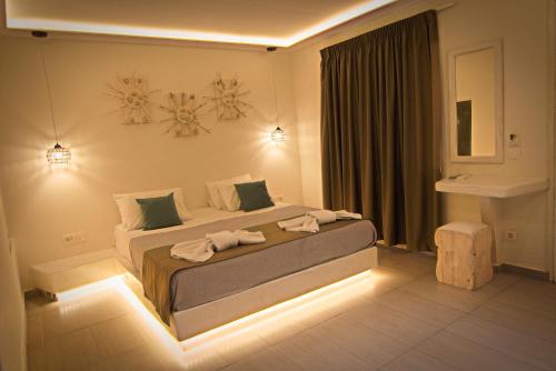 a bedroom with a large bed with lights on it at Sea Wave Hotel in Perissa