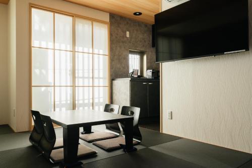 a dining room with a table and chairs and a kitchen at Weskii Hotel in Kanazawa