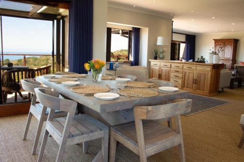 a kitchen and dining room with a table and chairs at Simbavati Fynbos on Sea in Sedgefield