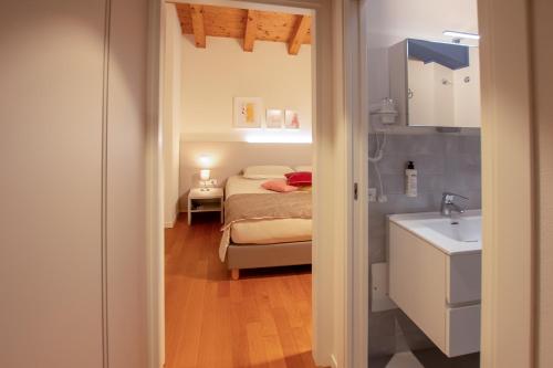 Dormitorio pequeño con cama y lavamanos en Hotel Residence Dolcenero en San Daniele del Friuli