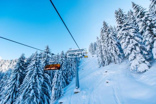 a ski lift in the middle of a snow covered forest at Alpendorf Hotel Stern in Sankt Johann im Pongau