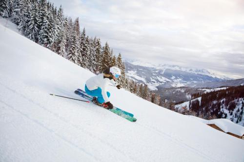 a person is skiing down a snow covered slope at Alpendorf Hotel Stern in Sankt Johann im Pongau
