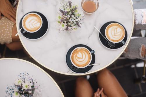 a group of cups of coffee on a table at Hôtel Du Centre, un hôtel AMMI in Nice