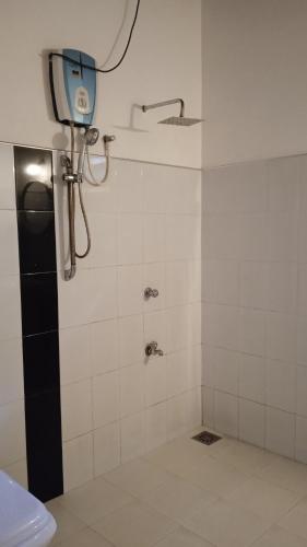 a bathroom with a shower with a camera on the wall at Gems Garden Guest House in Tangalle