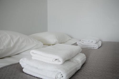 a pile of towels sitting on top of a bed at Vytautas Park Apartment with FREE Parking in Marijampolė
