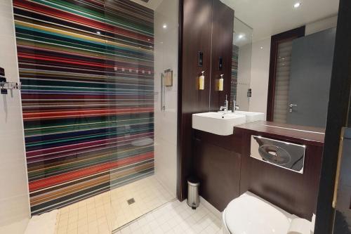 a bathroom with a toilet and a sink at Village Hotel London Watford in Elstree