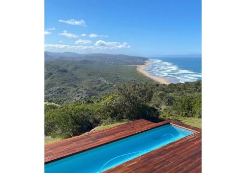 a swimming pool on the roof of a house with a beach at Simbavati Fynbos on Sea in Sedgefield