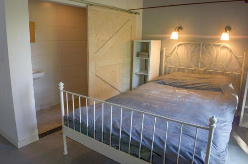 1 dormitorio con cama y puerta de granero en Huisje en B&B Green Cottage, en Groesbeek