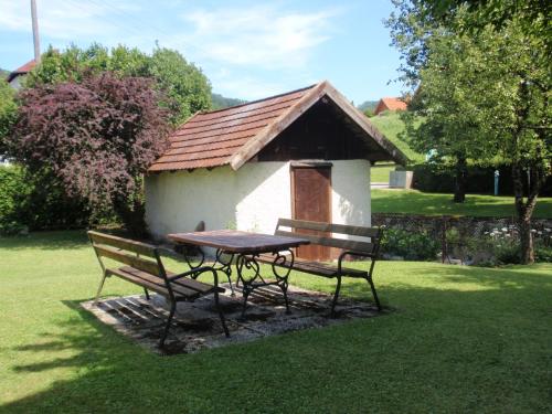a picnic table and bench in front of a small building at Ferienwohnungen Kern in Weyregg