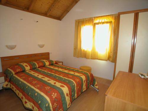 a bedroom with a bed and a window at Villas Oleandri in Vrboska