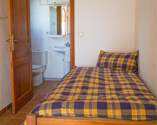a bed with a blue and yellow plaid pillow in a bathroom at Casa Inca, Villa with heatable pool and top view atop Moraira El Portet in Cumbre del Sol