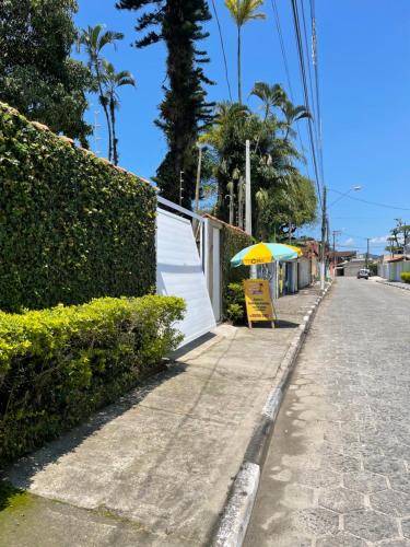 a yellow and green umbrella sitting on the side of a street at BERTIOGA suítes na praia centro in Bertioga