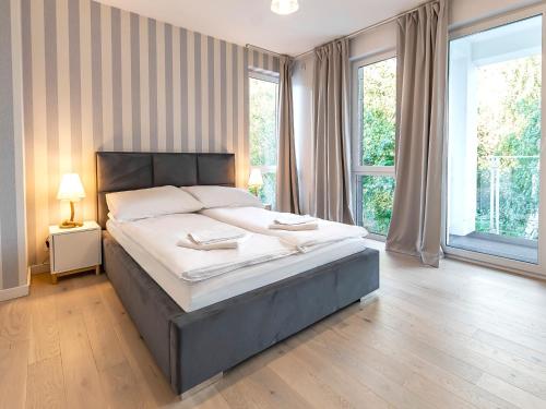 1 dormitorio con cama grande y ventana grande en VacationClub – Orłowska Riwiera Apartament A6, en Gdynia