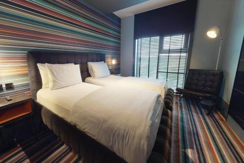 Village Hotel London Watford في إلستري: غرفة الفندق بسرير كبير ومكتب