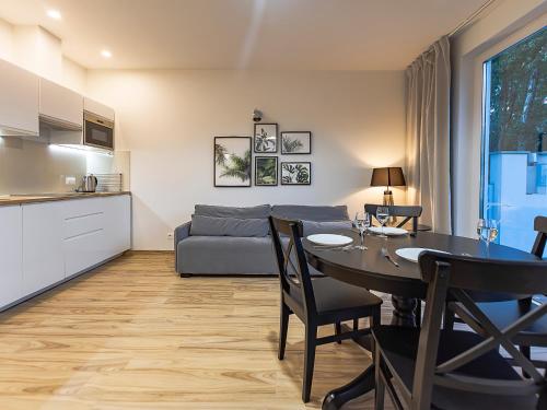 een woonkamer met een tafel en een bank bij VacationClub – Orłowska Riwiera Apartament A2 in Gdynia