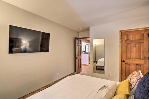 a bedroom with a bed and a tv on the wall at Cozy Blue River Cabin with Treehouse 6 Mi to Skiing in Blue River
