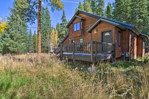 a log cabin in the woods with a deck at Cozy Blue River Cabin with Treehouse 6 Mi to Skiing in Blue River