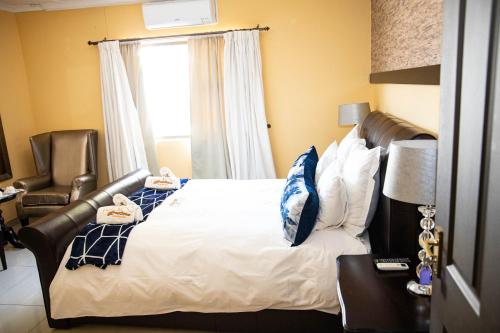 a bedroom with a bed with a leather headboard and a window at A-Z Boutique Guesthouse in Windhoek