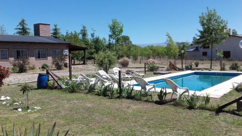 un grupo de sillas sentadas alrededor de una piscina en Cabañas Hilario en Los Reartes