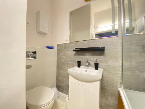 a white bathroom with a toilet and a sink at Kamienica Monte Cassino Sun I 7 min plaża I 2 sypialnie I Balkon in Sopot