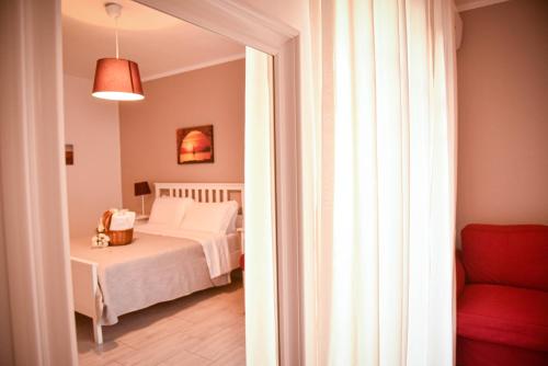 a bedroom with a bed and a red chair at A Casa dei Bruno B&B in Pozzuoli