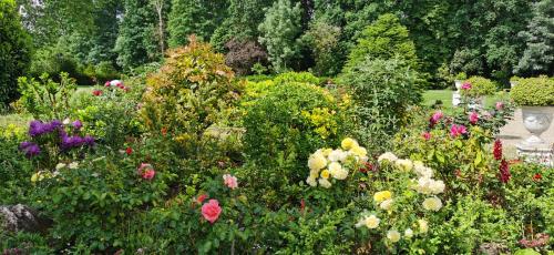 a garden filled with colorful flowers and a vase at CHATEAU DE BRINVILLE in Saint-Sauveur-sur-École