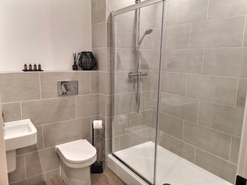 a bathroom with a shower and a toilet and a sink at Haworth Hideaway in Haworth
