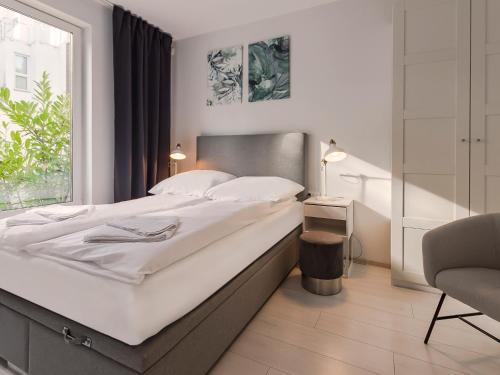 1 dormitorio con 1 cama grande y 1 silla en VacationClub – Orłowska Riwiera Apartament B2, en Gdynia