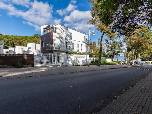 a white house on the side of a street at VacationClub – Orłowska Riwiera Apartament B2 in Gdynia