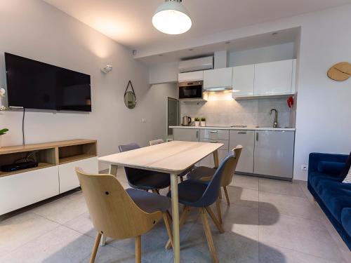 cocina y comedor con mesa y sillas en VacationClub – Orłowska Riwiera Apartament B2, en Gdynia