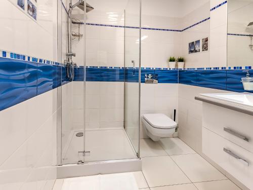 a bathroom with a shower and a toilet and a sink at VacationClub – Orłowska Riwiera Apartament B2 in Gdynia